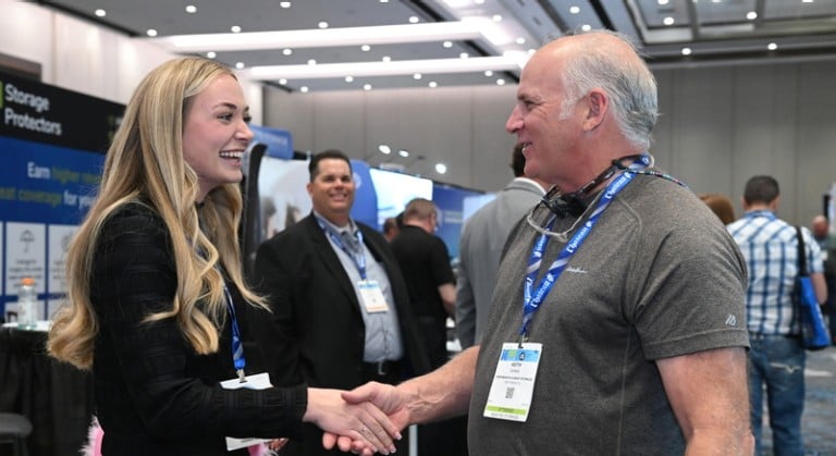 Exhibitor shaking hands with an attendee at ISS World Expo